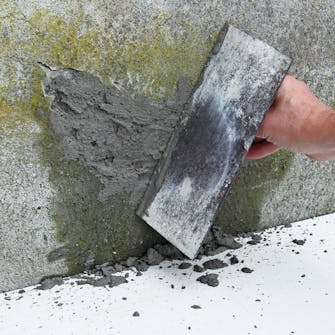 Sprekk i grunnmur: Mørtelen kastes på det lett fuktige området i små kladder med en murskje Sprekk i grunnmur: Mørtelen kastes på det lett fuktige området i små kladder med en murskje